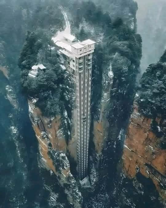 El ascensor Bailong, conocido también como el «Ascensor de los Cien Dragones», es una maravilla de la ingeniería moderna y una impresionante atracción turística ubicada en la pintoresca zona de Wulingyuan, en Zhangjiajie, China. Este ascensor de cristal, que ostenta el récord mundial como el ascensor al aire libre más alto y pesado del mundo, ofrece a los visitantes unas vistas espectaculares del paisaje montañoso y las formaciones rocosas que inspiraron la película «Avatar». Con una altura de 326 metros, el ascensor Bailong no solo facilita el acceso a las elevaciones más altas del parque, sino que también brinda una experiencia única al ascender a través de un acantilado empinado, revelando panoramas asombrosos a medida que se eleva.